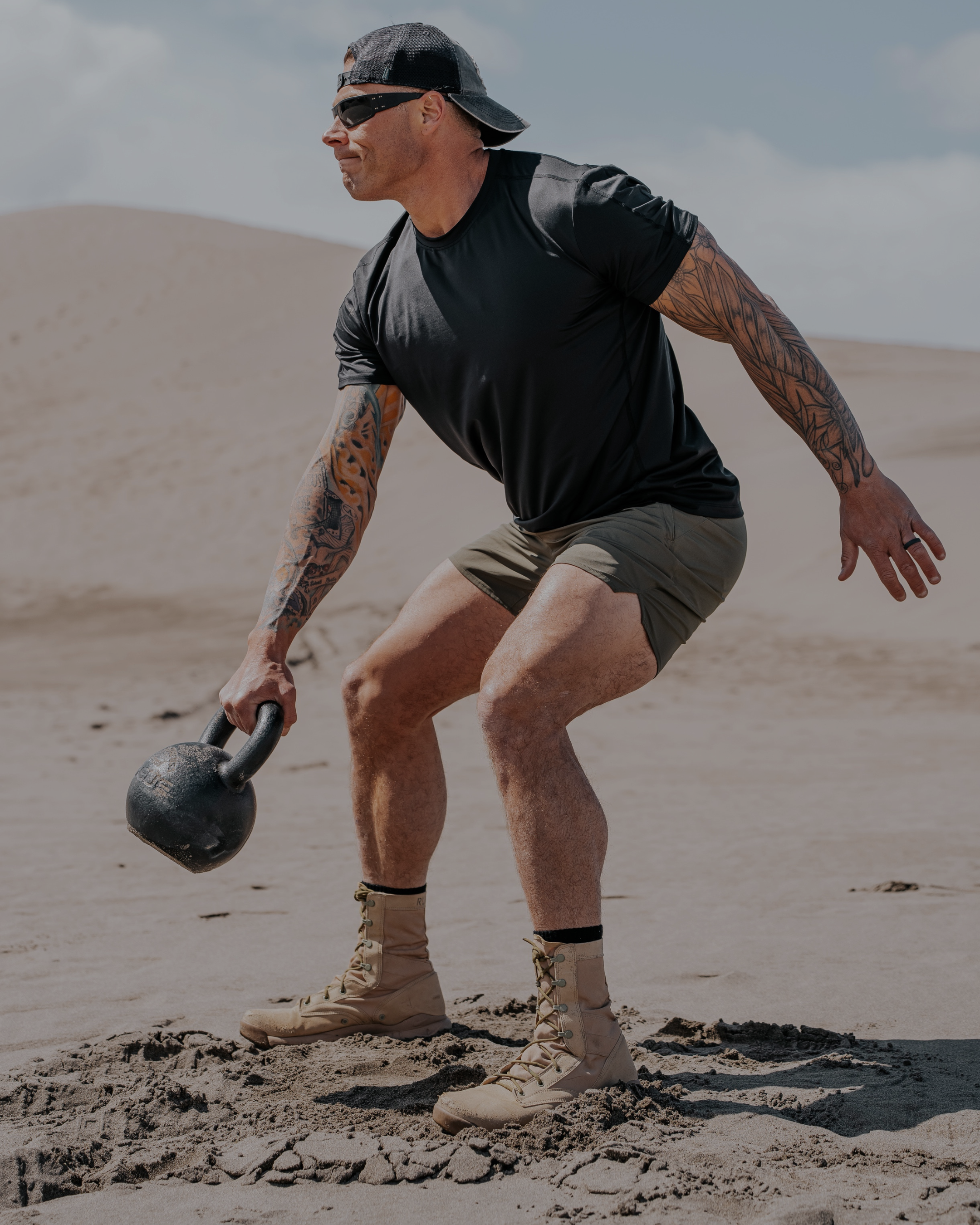 Man exercising with a kettlebell in a desert setting