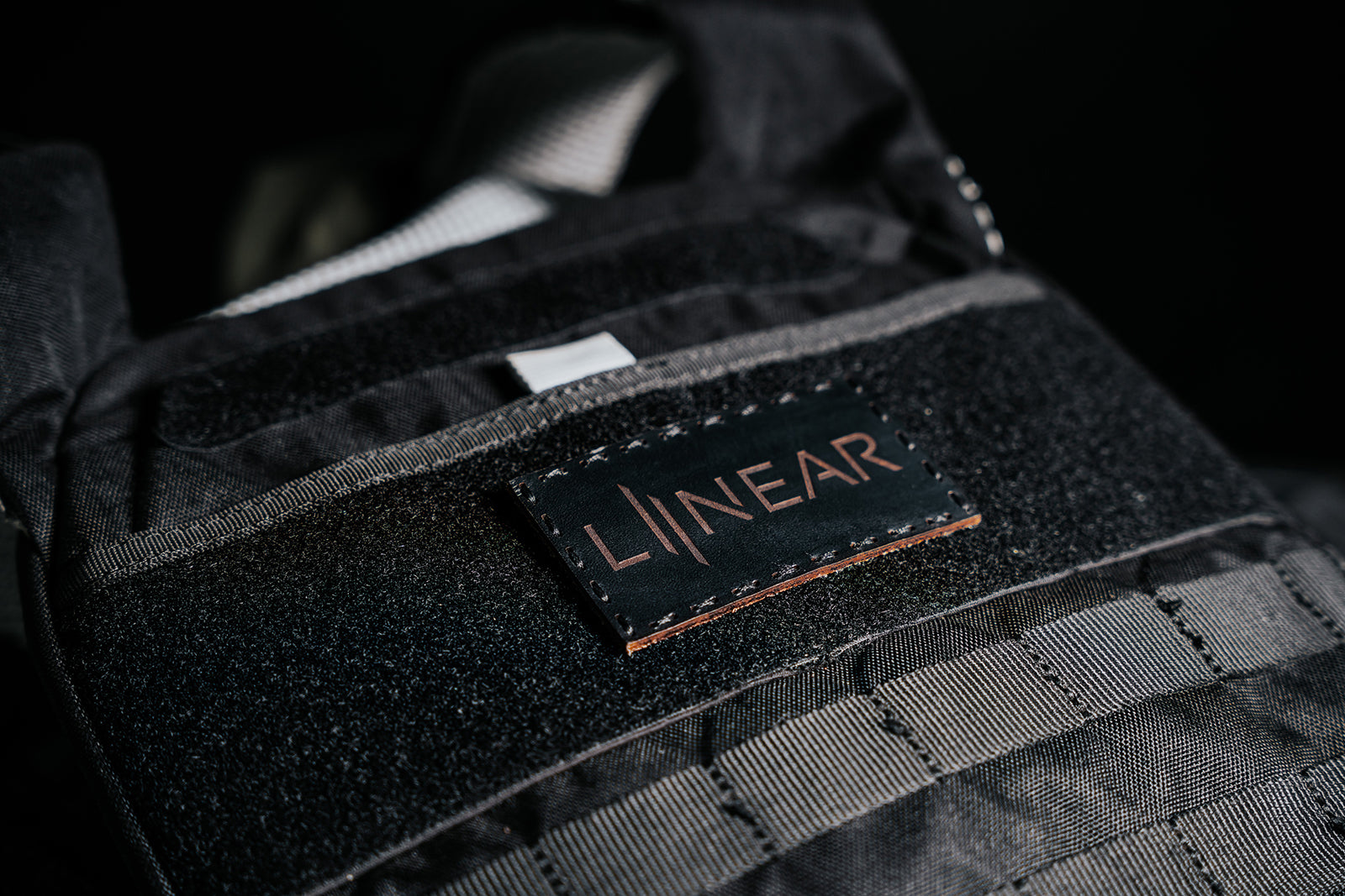 Close-up of a black weight vest with Night Ops Black LINEAR® Team Patch