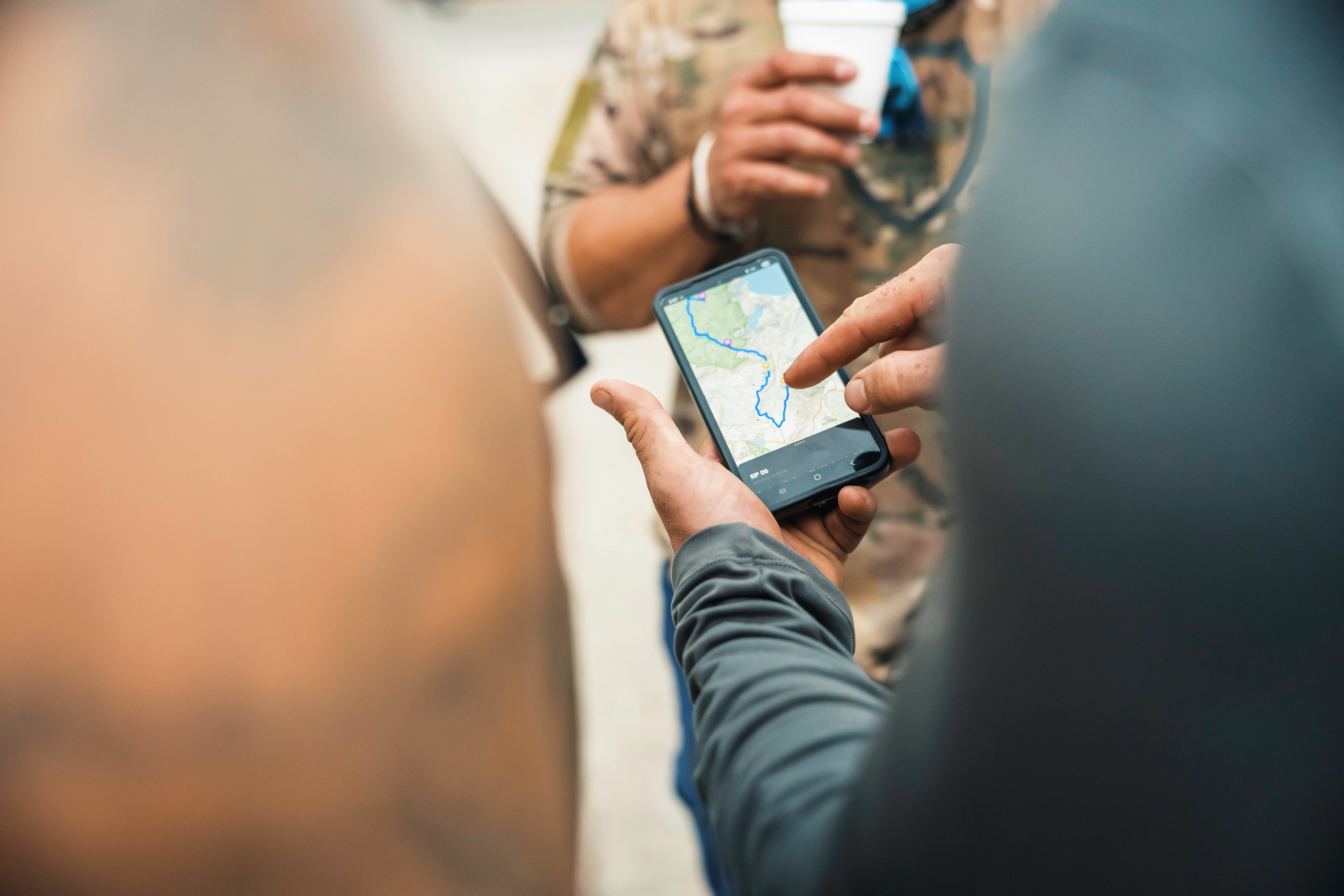Person using a smartphone with a map app, blurred background to map the 20 Mountain 220 journey.