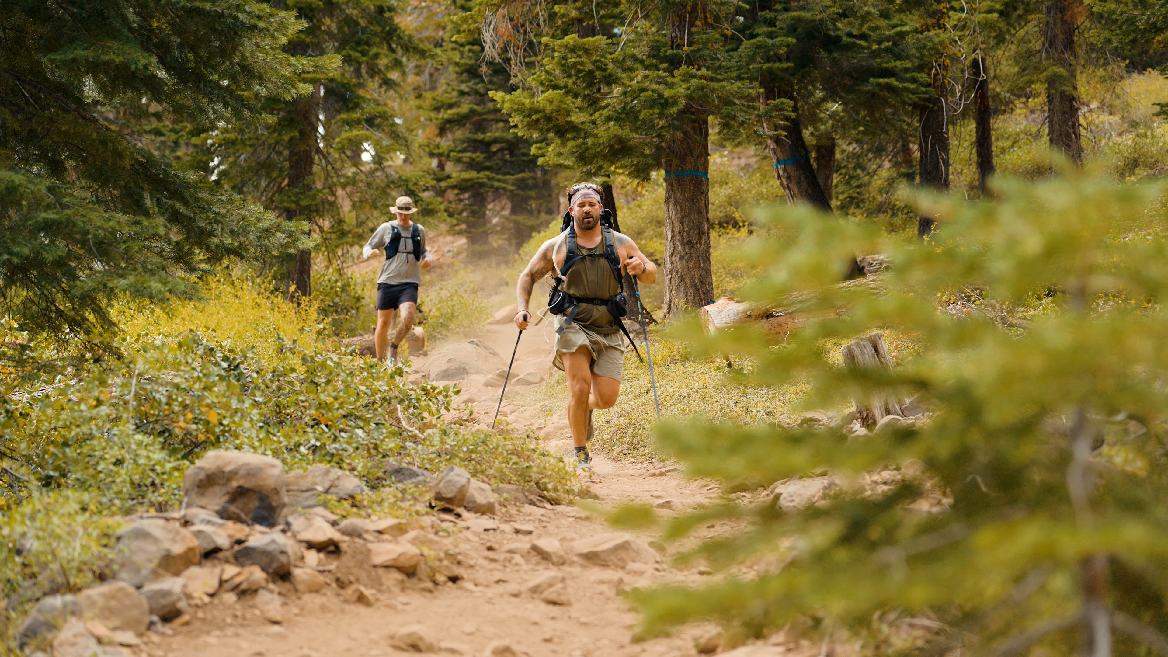 Navy Seal Kyle Reed with another hiker on a trail through a forest during the 20 Mountain 220