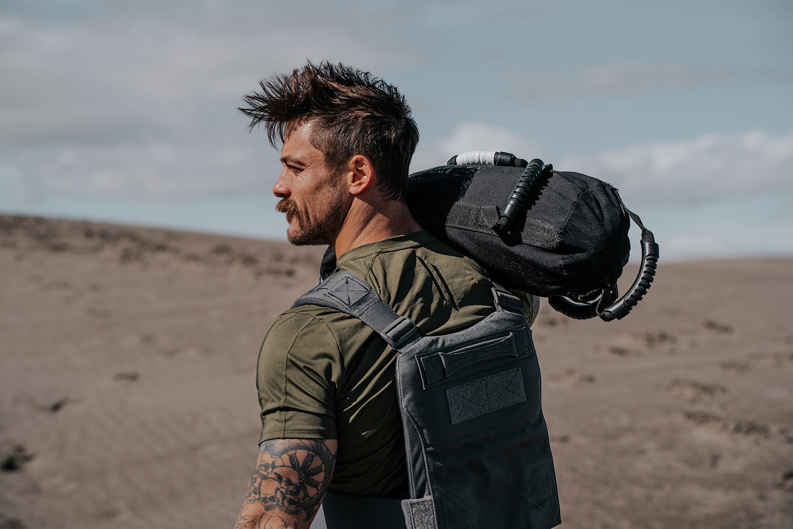 Man with a backpack in a desert landscape wearing LINEAR Baseline series shirt