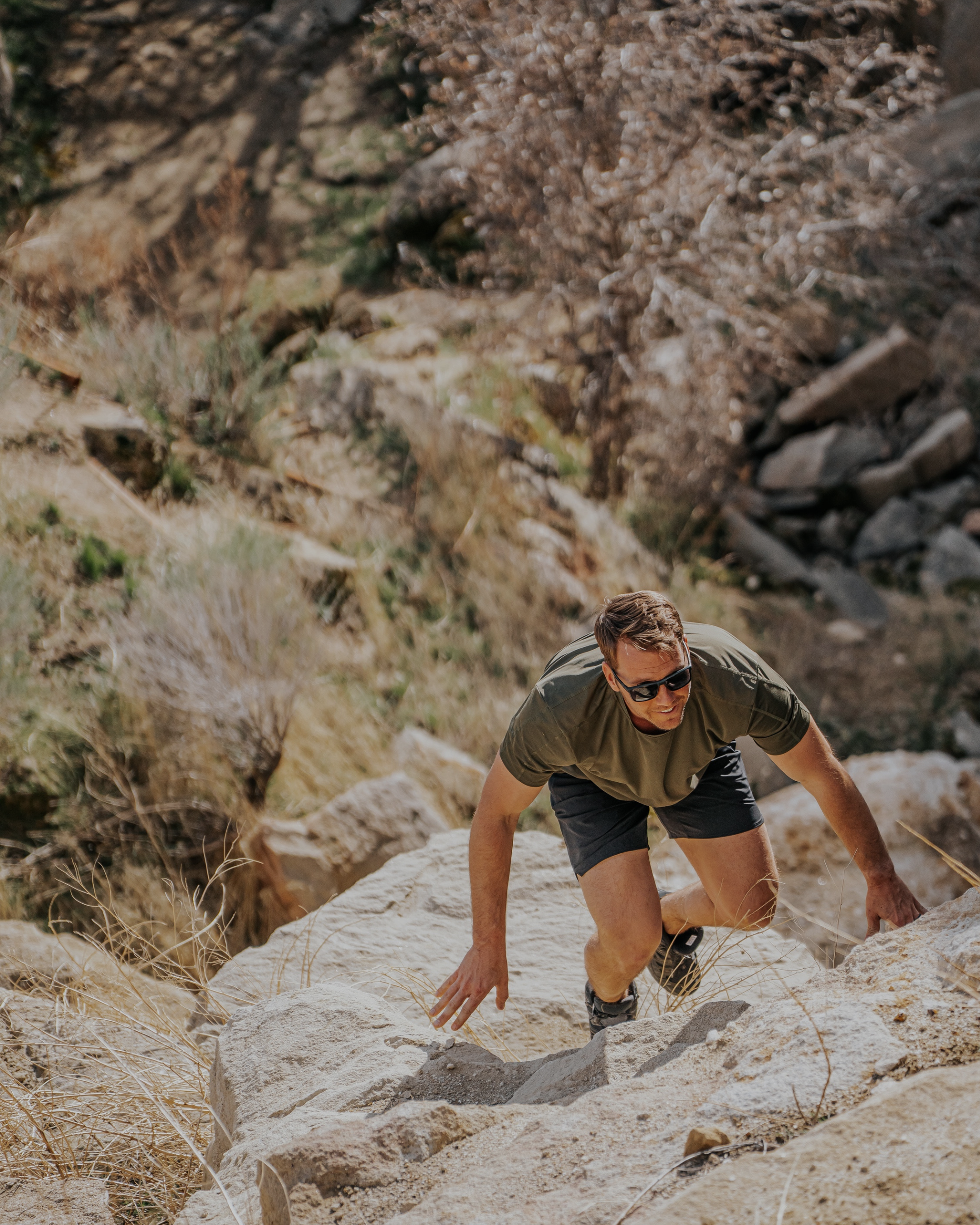 Man climbing a rocky mountain trail in a natural setting