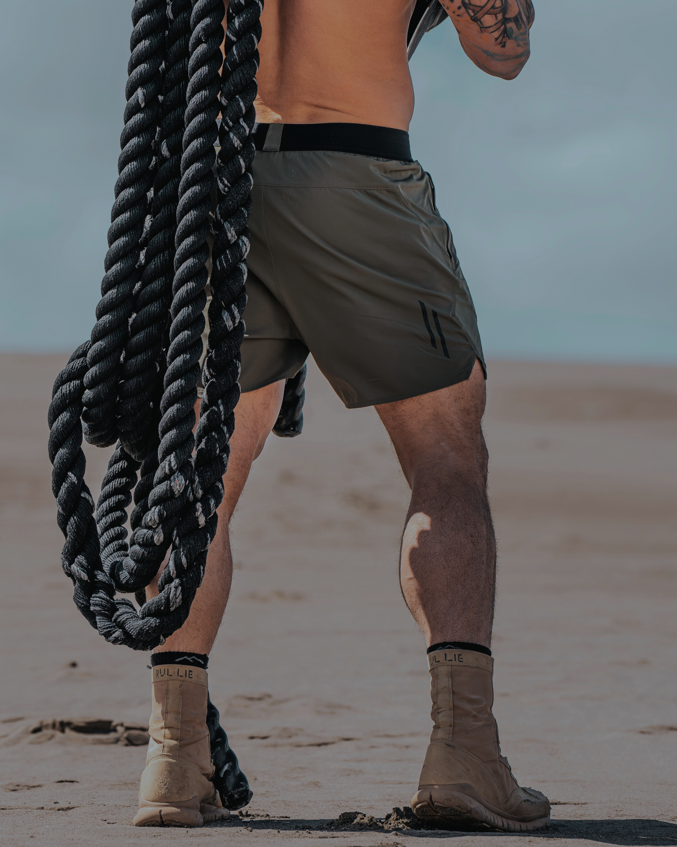 Person holding large ropes in the desert