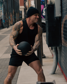 Man holding a medicine ball on a city street