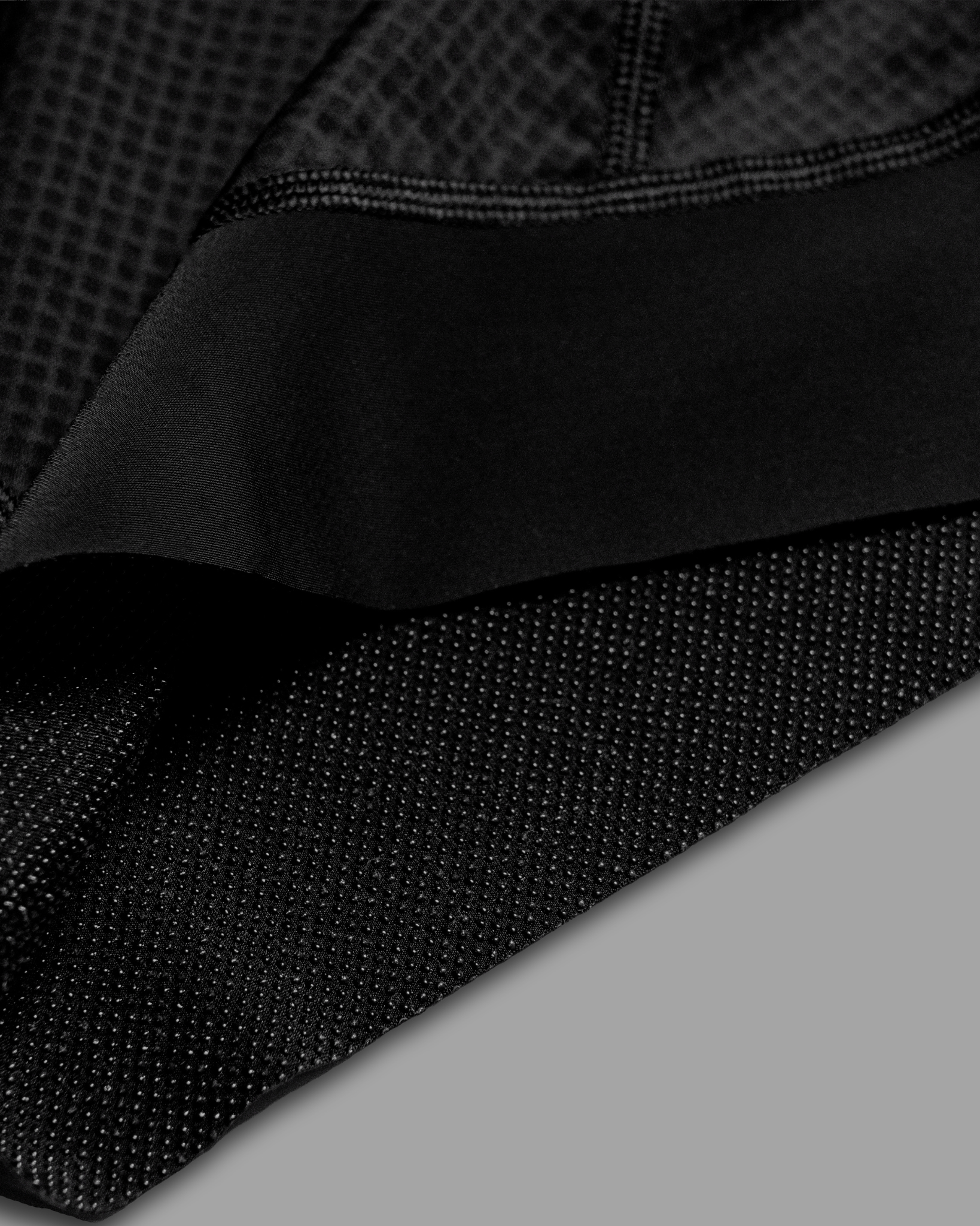 Close-up of black textured fabric on a gray background