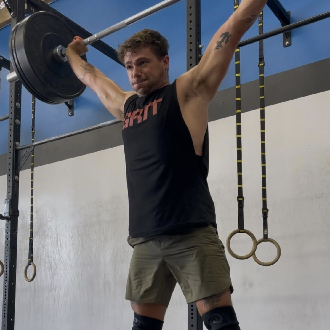 LINEAR® customer Joeseph G performing a barbell press in a gym setting wearing the baseline series shorts in ODA green