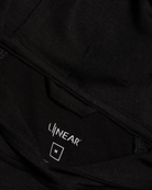 Close-up of a black hoodie with 'LINEAR' logo on the chest pocket.