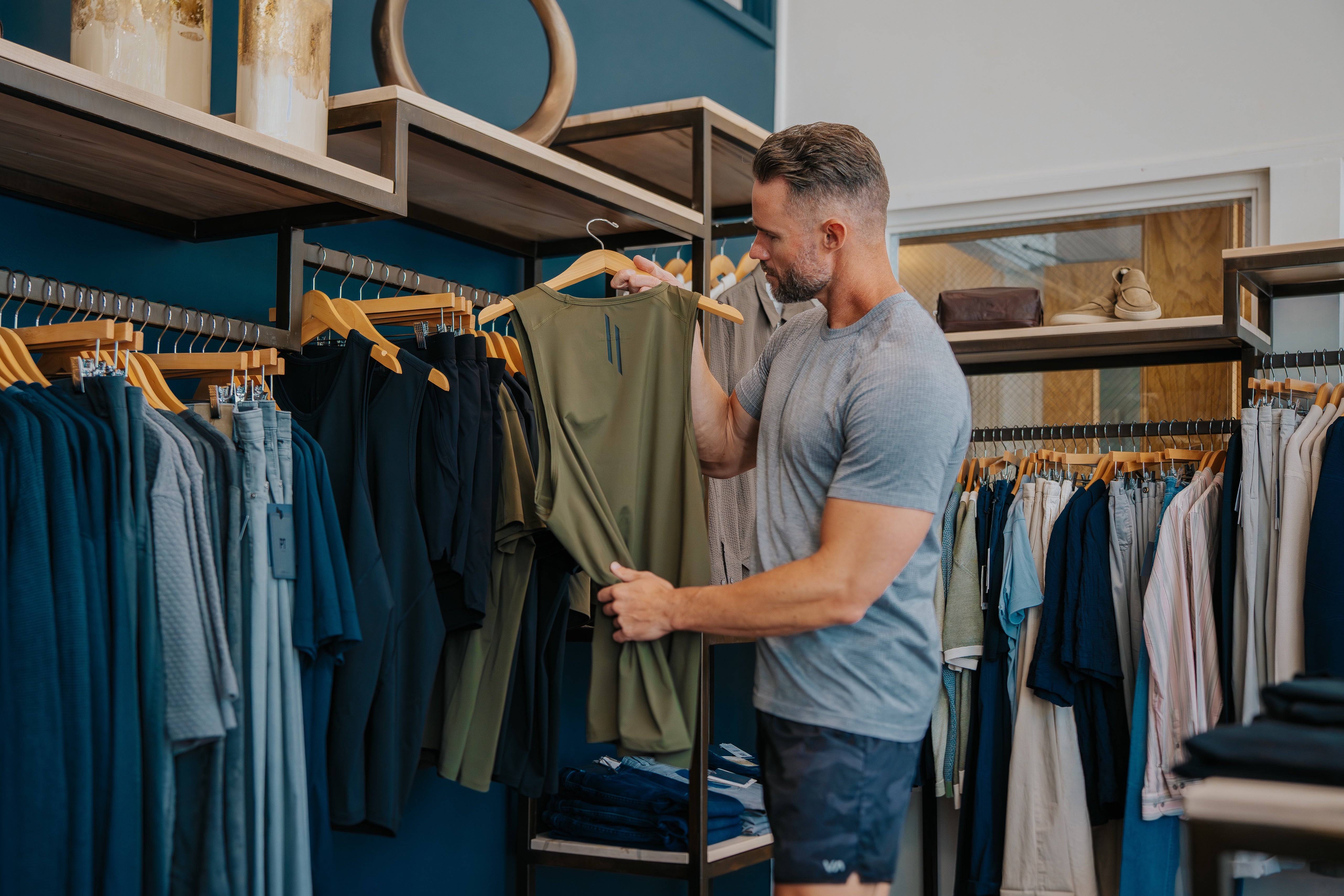Man looking at a LINEAR Baseline tank in ODA Green at the SALT For MEN clothing store in Boise Idaho