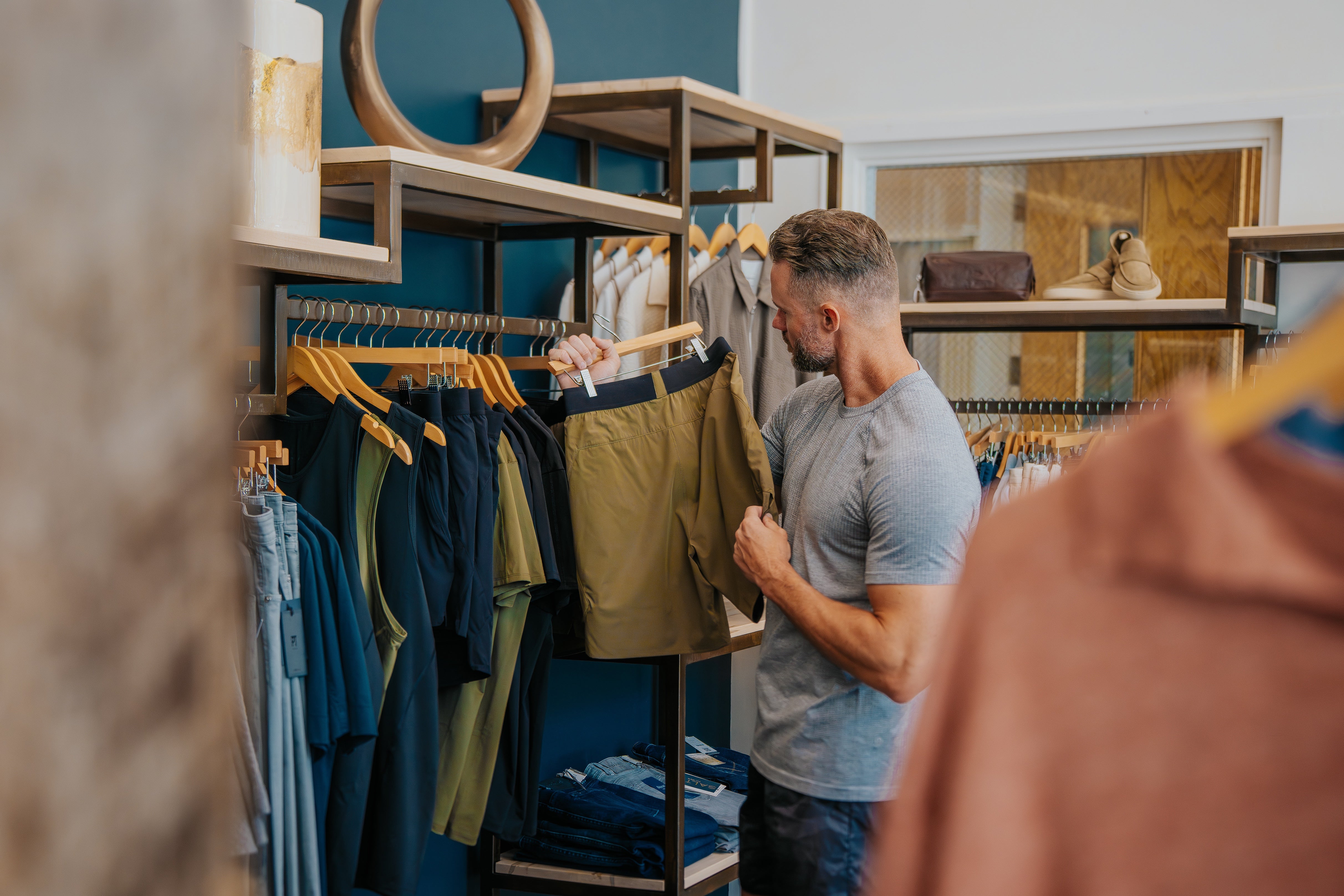 Man holding a LINEAR Baseline shorts in ODA Green at the SALT For MEN clothing store in Boise Idaho